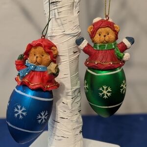 Two Christmas Bears Sitting On Blue and Green Ornaments